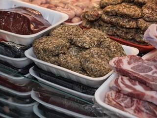 Raw beef steak on a white plate in a restaurant setting. Chef cutting fresh meat before cooking.