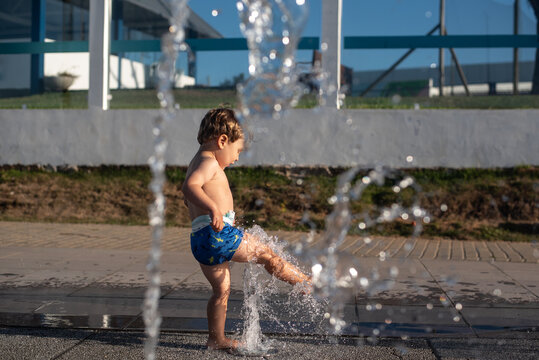 Boy kicking water at a splash pad