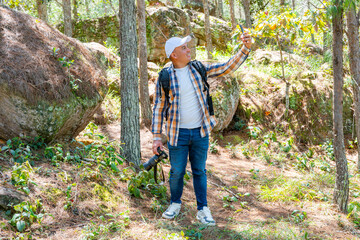 Centered photographer on video call in pine forest