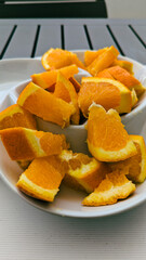 Fresh Orange Slices in White Bowl.
Juicy orange wedges served in a white bowl on an outdoor table, perfect for a healthy snack or breakfast.