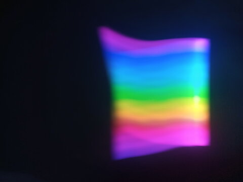 A multicolored abstract by moving strokes of light, creating bright, swirling streaks of rainbow-colored light on a dark background