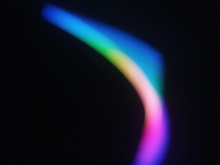 A multicolored abstract by moving strokes of light, creating bright, swirling streaks of rainbow-colored light on a dark background