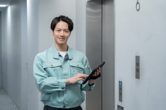 オフィスをメンテナンスをする男性作業員 - Powered by Adobe