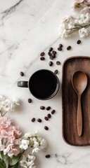 Flatlay of coffee cup, beans, flowers, and wooden spoon on marble