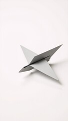 Fototapeta premium A single-sheet origami white paper airplane isolated on a pristine white background
