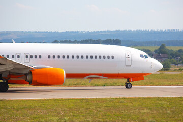 Aircraft taxiing on the runway during daytime at a regional airport in a rural area