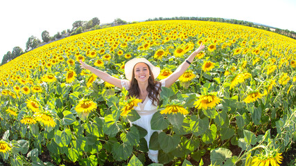 Fototapeta premium Woman enjoying sunny day in vibrant sunflower field during summer