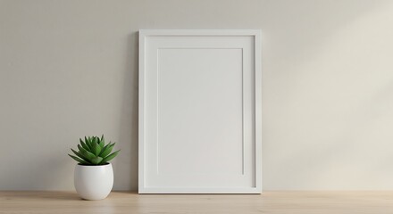 A minimalist interior scene featuring a blank white frame and a small succulent plant.