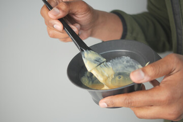 Mixing hair color in a black bowl with a brush