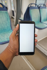 Holding a smartphone in an empty train cabin