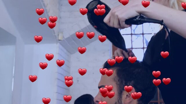 Stylist switching on hair dryer and blow-drying client hair in salon, with floating hearts rising
