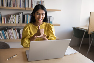 Indian woman interacting, showing gestures, using sign language at video call, engaging in conversation with person with communication disorder, lead online class. Inclusivity, digital communication