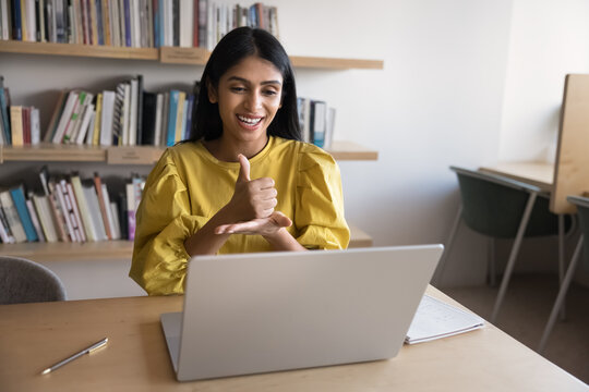 Indian woman interacting, showing gestures, using sign language at video call, engaging in conversation with person with communication disorder, lead online class. Inclusivity, digital communication