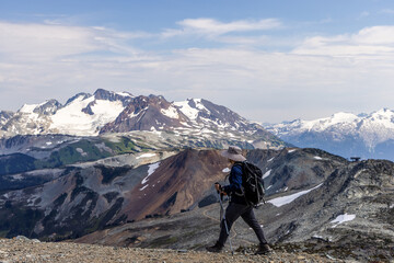 Fototapeta premium Hiker Exploring Scenic Mountain Trail in Whistler, BC with Stunning Peaks