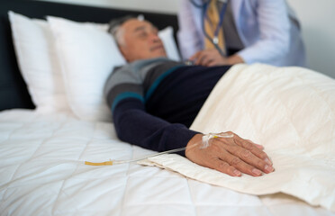 scene of bedridden patient, focus on hand of illness elderly hopeless senior man lying on bed. home caregiver nurse visit retirement patient for health check up recovery process medical service