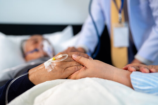 scene of bedridden patient, focus on hand of wife holding hands illness elderly hopeless senior man. home caregiver nurse visit retirement patient for health check up recovery process medical service - Powered by Adobe