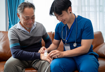 asian physiotherapist change wound dressing or bandage for senior man to take care wound. home...