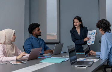 multiracial business cooperation sitting in boardroom with laptop computer,tablet and documents,meeting in company,asian business woman in suit present strategic goals and results