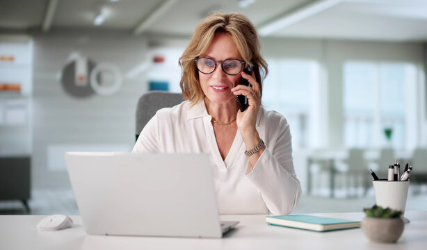 Successful Senior Businesswoman Speaking With Client On Smartphone - Powered by Adobe