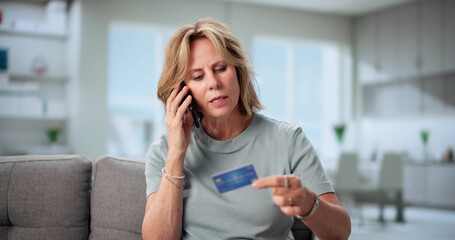 Protecting The Elderly: Senior Woman Confronting Pension Fraud Phone