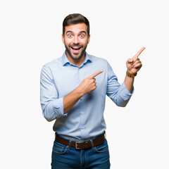 Handsome young businessman with a charming smile is standing, pointing a finger at you while holding his mobile phone