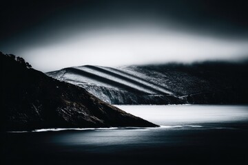 Dramatic coastal scene, dark moody hills meet a misty water's edge