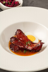 Barbecue pork slices with hard-boiled egg in a savory brown sauce