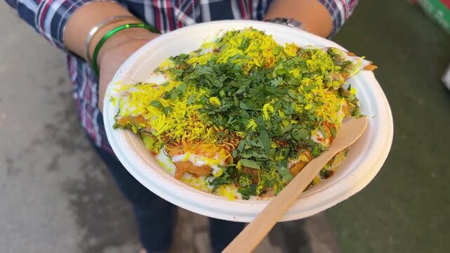 Palak chat sold in streets of India garnished with coriander leaves