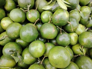 Heap of Fresh Green Oranges Close Up Vibrant Citrus Fruit Display Pile of Tangy Oranges for Healthy Eating Promotion