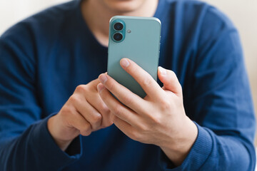 ベッドの上でスマートフォンを操作する若い男性　ライフスタイルイメージ