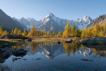 Fototapeta premium Autumnal mountain lake reflecting snowy peaks