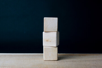 Three empty wooden blocks are stacked on the table.