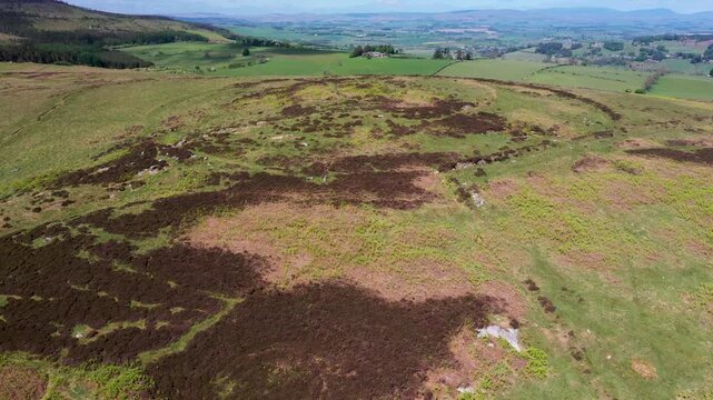 Lordenshaw small multivallate Iron Age hillfort on Garleigh Moor in the Simonside Hills south of Rothbury, Northumberland, England. Aerial view to north west. 4k video fly up in