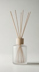 Frosted glass diffuser bottle with reeds on white background