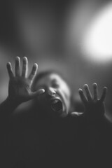 Scary picture of hands behind glass, horror ghost behind door, Halloween concept