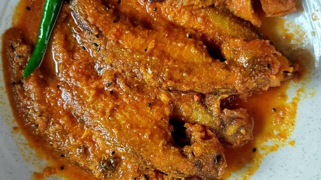 Bengali-style pabda fish jhal with tomato bata &ndash; traditional Indian mustard fish curry, spicy river fish recipe, homestyle Bengali cuisine, served in bowl