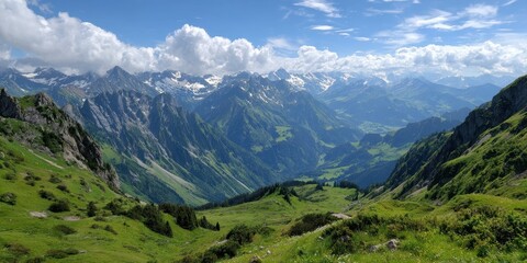 Fototapeta premium A breathtaking vista unfolds across a verdant mountain valley, with majestic peaks rising towards a sky adorned with fluffy white clouds, creating a serene and awe-inspiring natural landscape.