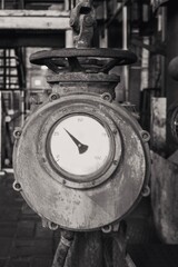 
very old shut-off device with measuring instrument in a disused industrial area