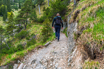 Obraz premium Happy Man with glasses and a black jacket and backpack along to the Bavarian hiking paths