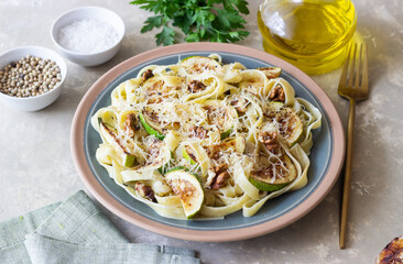 Fettuccine pasta with zucchini, nuts and parmesan cheese. Healthy eating. Vegetarian food. Italian cuisine.