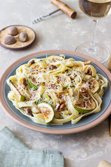 Fettuccine pasta with zucchini, nuts and parmesan cheese. Healthy eating. Vegetarian food. Italian cuisine.