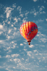 Fototapeta premium A Serene Escape: The Delicate Ascent of a Balloon as it Gracefully Rises into the Sky, Capturing the Essence of Freedom and Tranquility Amidst the Lofty Heights