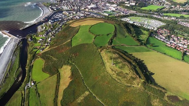 Iron Age Celtic multi-phase hillfort earthworks ramparts on top of Pen Dinas hill immediately S. of Aberystwyth. Dyfed, Wales. 4k video clockwise rotate looking N.E.