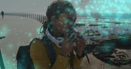 Woman adjusting headphones, eating sandwich for health snack with teal green particles drifting