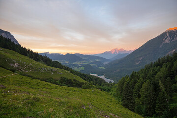 Fototapeta premium Magischer Sonnenuntergang an der Halsalm über dem Hintersee mit Blick zum Hoher Göll, Hochkalter und Untersberg.