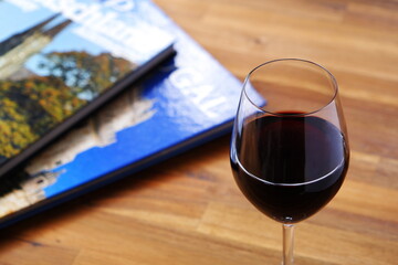 Glass of red wine with books on table
