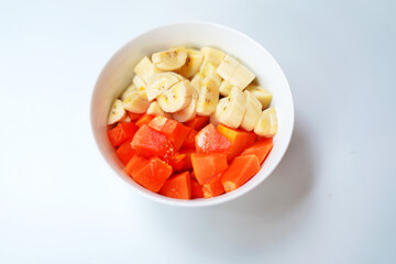 Papaya and Banana Fruits in White Bowl on White Background – Healthy Breakfast Concept.