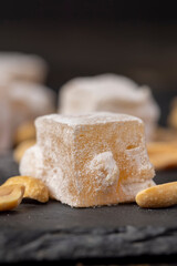 sugar cubes with starch and toasted peanuts on a black slate surface, side view