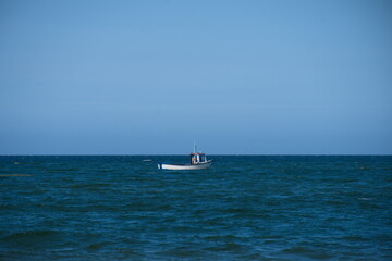 Small fishing boat floating in the ocean alone