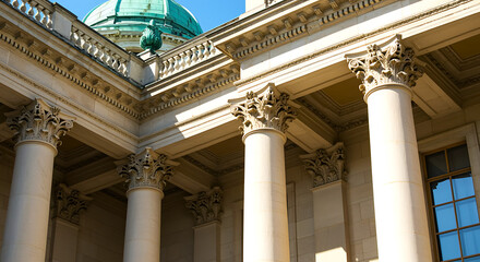 Obraz premium Majestic architectural detail of a grand building featuring ornate columns and a green dome against a clear blue sky